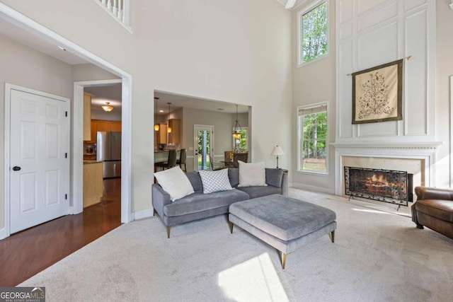 2745 Princeton Trce, Cumming, GA 30041 - carpeted living room with a warm lit fireplace, a wealth of natural light, and a towering ceiling