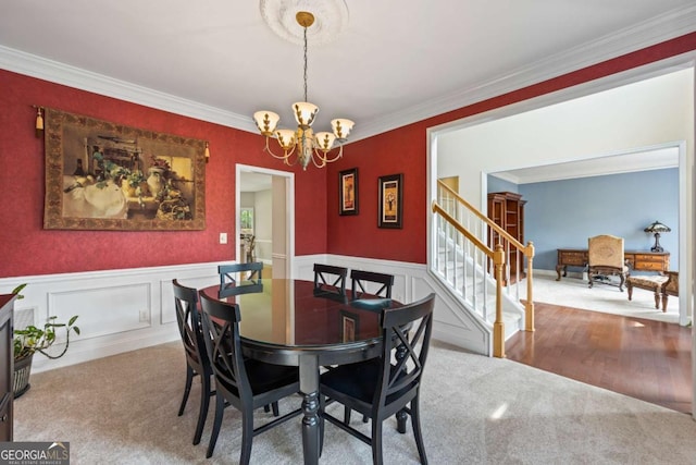 2745 Princeton Trce, Cumming, GA 30041 - carpeted dining space with crown molding, a notable chandelier, a wainscoted wall, and stairs