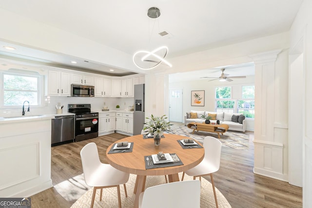 1258 Lyle Ave, East Point, GA 30344 - dining space featuring recessed lighting, light wood-style flooring, a wealth of natural light, and decorative columns