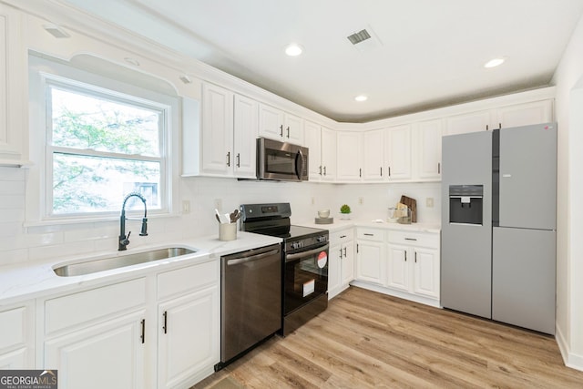 1258 Lyle Ave, East Point, GA 30344 - kitchen with decorative backsplash, visible vents, a sink, white cabinets, and stainless steel appliances