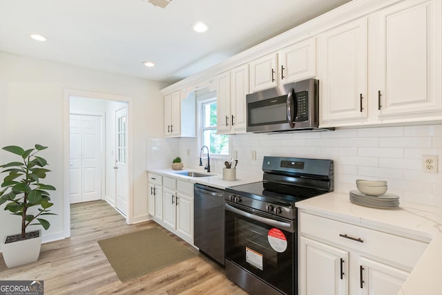 1258 Lyle Ave, East Point, GA 30344 - kitchen featuring a sink, appliances with stainless steel finishes, light wood-style flooring, and white cabinetry