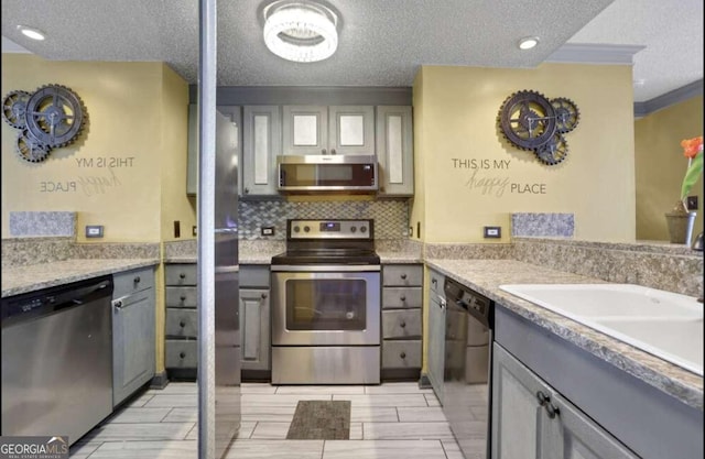 375 Ralph Mcgill Blvd # 1503, Atlanta, GA 30312 - kitchen featuring stainless steel appliances, a textured ceiling, gray cabinetry, tasteful backsplash, and light countertops
