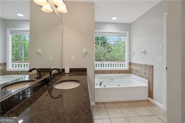bathroom with vanity, tile patterned flooring, and a tub with jets
