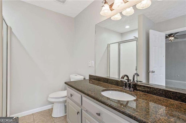 full bath featuring a shower stall, toilet, vanity, baseboards, and tile patterned flooring