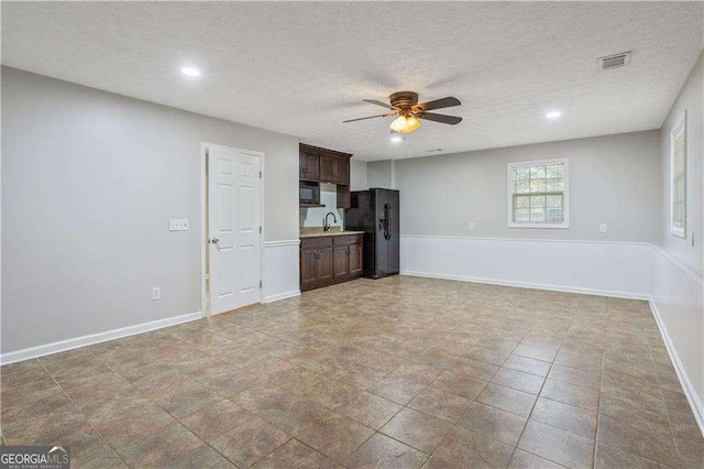 unfurnished living room with a textured ceiling, baseboards, visible vents, recessed lighting, and ceiling fan