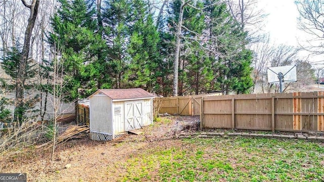 view of yard with a fenced backyard, an outbuilding, and a storage unit