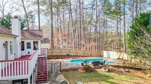view of swimming pool featuring a wooden deck, a fenced backyard, and a fenced in pool