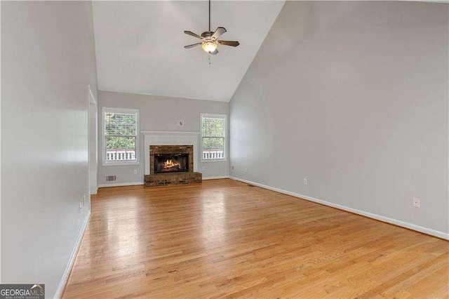 unfurnished living room featuring visible vents, baseboards, a ceiling fan, wood finished floors, and high vaulted ceiling