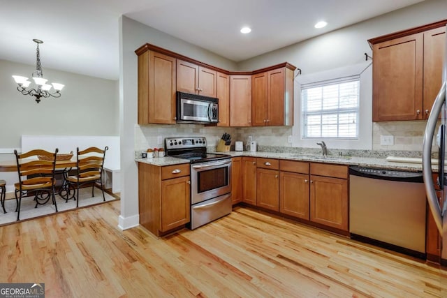 90 Hart Ave, Athens, GA 30606 - kitchen with stainless steel appliances, light wood-style floors, brown cabinetry, backsplash, and recessed lighting