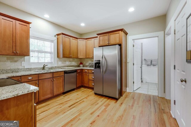 90 Hart Ave, Athens, GA 30606 - kitchen with appliances with stainless steel finishes, backsplash, brown cabinets, light wood-type flooring, and recessed lighting
