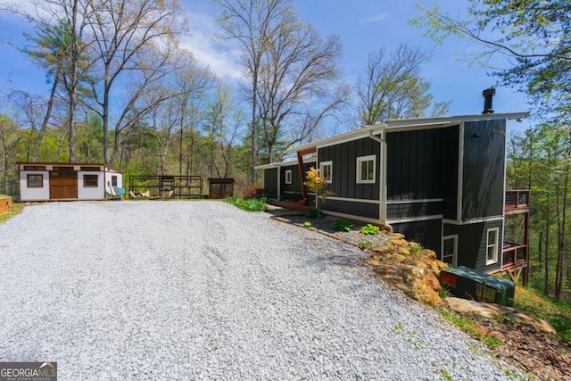 124 Nichols Branch Ln, Clayton, GA 30525 - view of home's exterior with board and batten siding, gravel driveway, and a storage shed