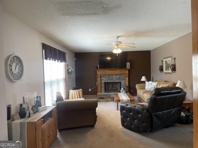 carpeted living area with ceiling fan, a textured ceiling, and a fireplace with raised hearth
