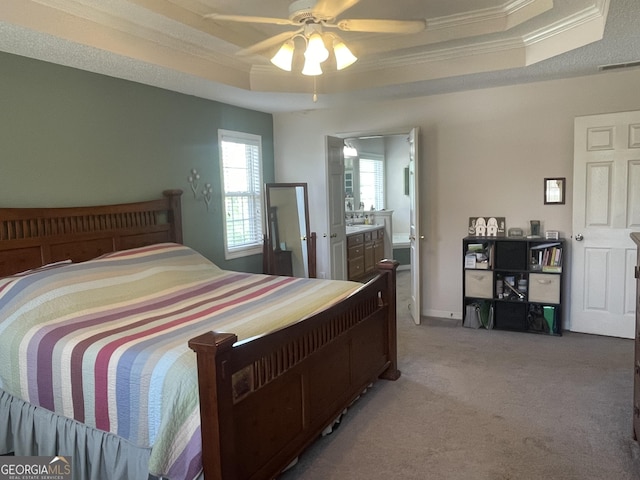 bedroom with crown molding, carpet flooring, a raised ceiling, and visible vents