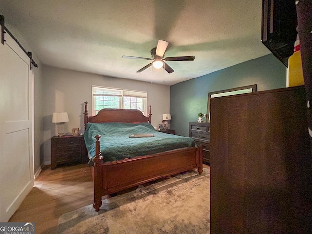 15 Laurelwood Cir, Griffin, GA 30224 - bedroom featuring ceiling fan, a barn door, baseboards, and wood finished floors