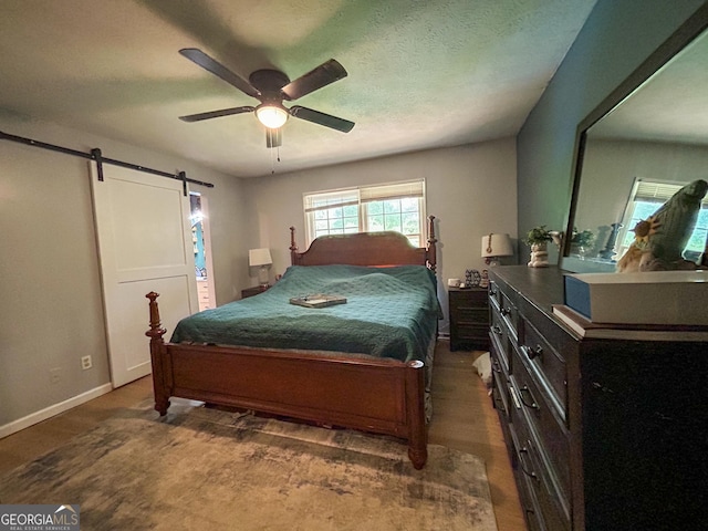 15 Laurelwood Cir, Griffin, GA 30224 - bedroom featuring a barn door, wood finished floors, baseboards, and ceiling fan