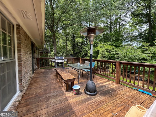 15 Laurelwood Cir, Griffin, GA 30224 - wooden deck featuring outdoor dining area, a grill, and view of wooded area