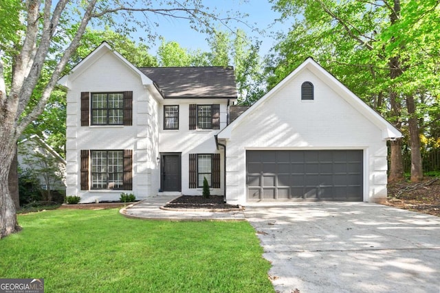 view of front of property featuring an attached garage, a front yard, and concrete driveway