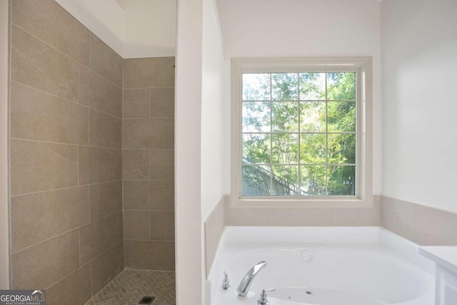 full bath with a bath and tiled shower