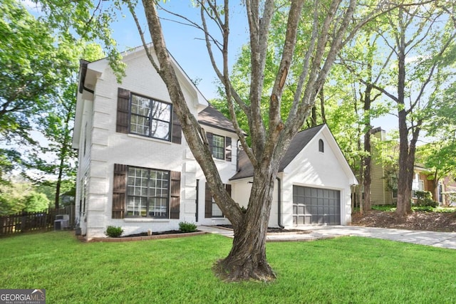 view of front of house with concrete driveway, a front yard, and fence
