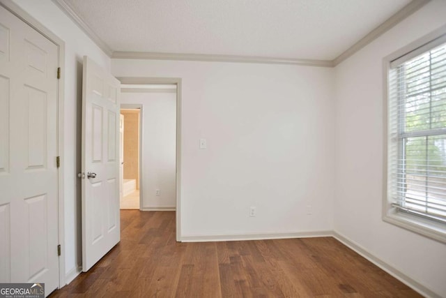 unfurnished room with baseboards, wood finished floors, and ornamental molding