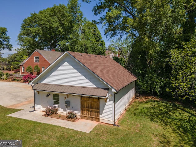 back of property featuring metal roof, a standing seam roof, and a yard
