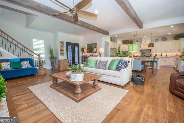 living area featuring light wood-type flooring, beamed ceiling, a ceiling fan, and recessed lighting