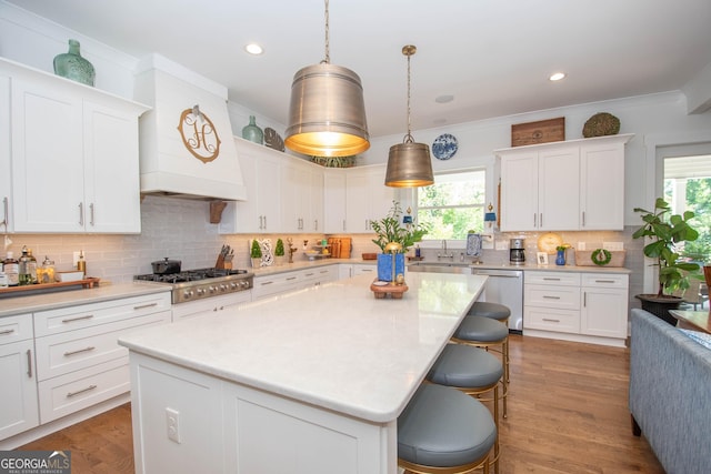 kitchen featuring stainless steel appliances, a wealth of natural light, a kitchen bar, and a sink