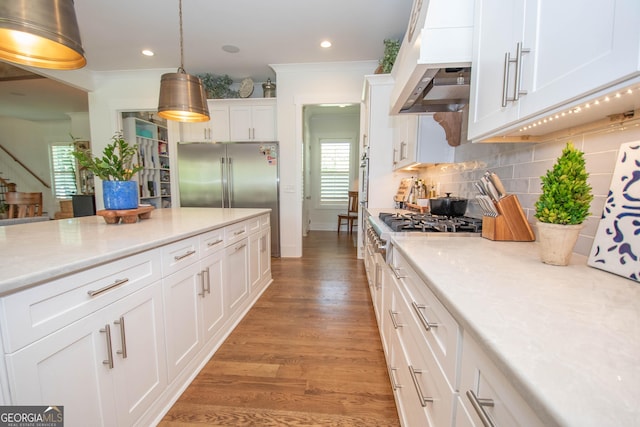 kitchen with light wood-type flooring, backsplash, light countertops, premium range hood, and white cabinets