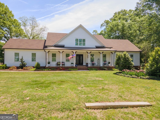 view of front of home with covered porch, a standing seam roof, and a front lawn