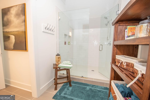 bathroom featuring baseboards, a stall shower, and tile patterned flooring