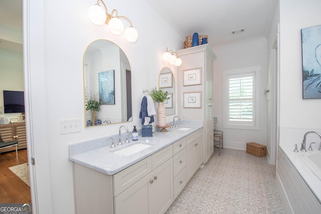 bathroom with double vanity, a sink, a relaxing tiled tub, and visible vents