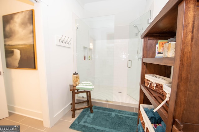 bathroom featuring baseboards, a shower stall, and tile patterned flooring