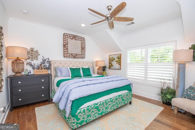 bedroom with baseboards, visible vents, wood finished floors, and crown molding
