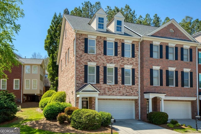 townhome / multi-family property featuring brick siding, an attached garage, and driveway