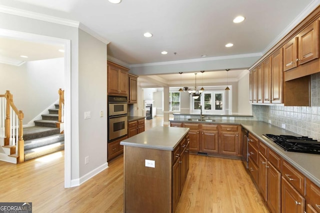 kitchen featuring light wood finished floors, a peninsula, a center island, stainless steel appliances, and recessed lighting