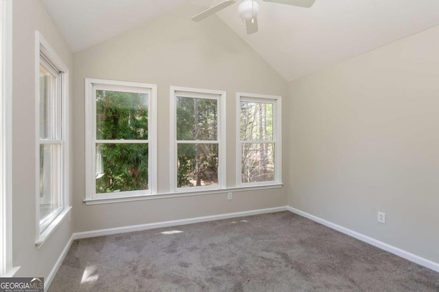 spare room featuring a ceiling fan, a wealth of natural light, carpet, and vaulted ceiling