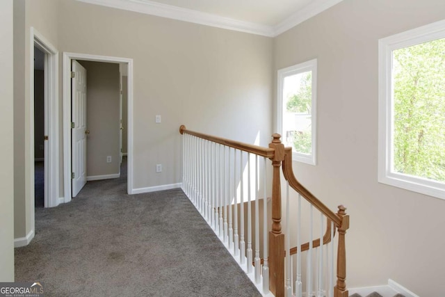 hall featuring carpet flooring, ornamental molding, an upstairs landing, and baseboards