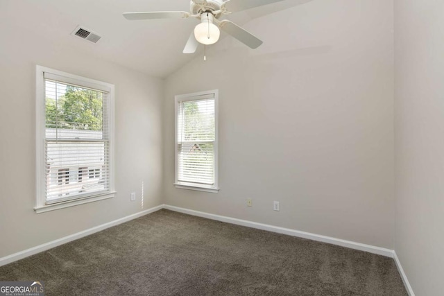 empty room with baseboards, dark carpet, visible vents, and plenty of natural light