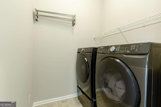 clothes washing area featuring laundry area, baseboards, separate washer and dryer, and tile patterned flooring
