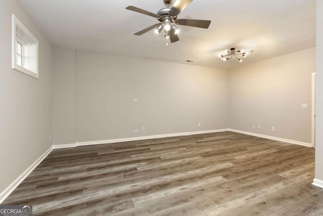 unfurnished room with a ceiling fan, baseboards, visible vents, and wood finished floors