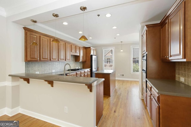 kitchen with high quality fridge, ornamental molding, a peninsula, and a kitchen island