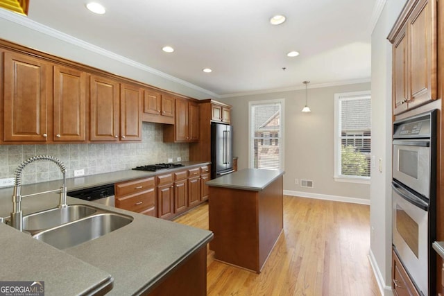 kitchen with a sink, stainless steel appliances, visible vents, decorative backsplash, and a center island