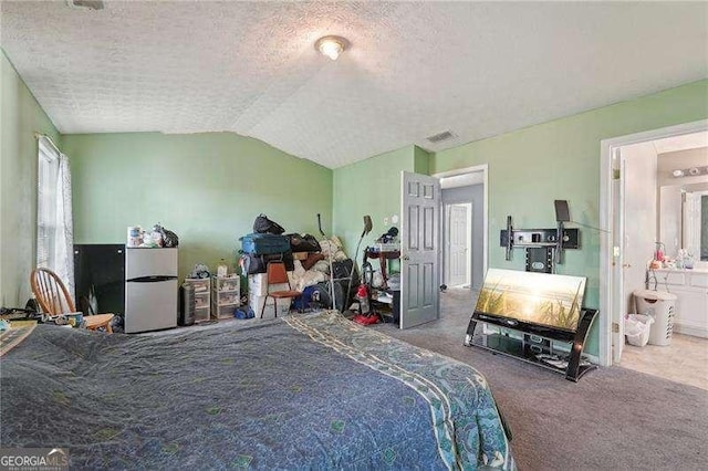 415 Clairidge Ln SW, Lawrenceville, GA 30046 - bedroom with a textured ceiling, freestanding refrigerator, carpet, lofted ceiling, and connected bathroom