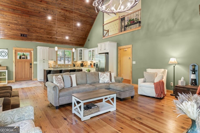 210 Lake Pines Rd, Jackson, GA 30233 - living area featuring baseboards, high vaulted ceiling, an inviting chandelier, and light wood-style floors