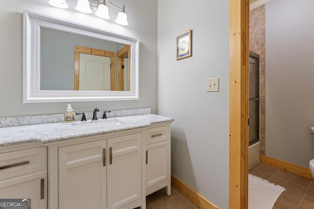 210 Lake Pines Rd, Jackson, GA 30233 - full bath featuring shower / bath combination with glass door, baseboards, toilet, vanity, and tile patterned flooring