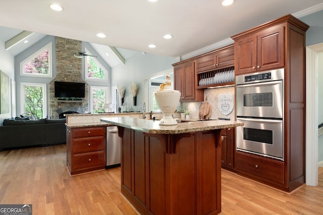 3190 Shumard Way, Marietta, GA 30064 - kitchen featuring stainless steel double oven, light stone counters, a center island, open floor plan, and a breakfast bar area