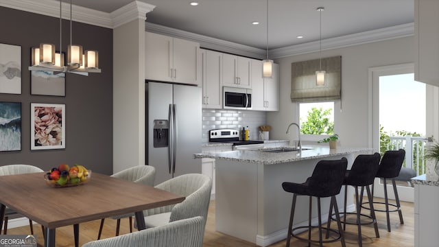 kitchen with stainless steel appliances, light wood-style flooring, a kitchen island with sink, a sink, and tasteful backsplash