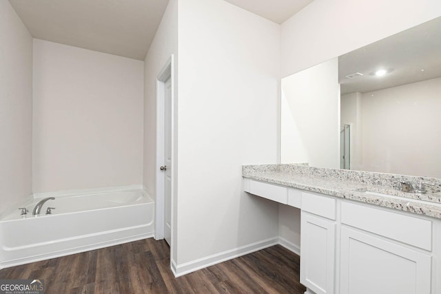 full bathroom with wood finished floors, a bath, vanity, baseboards, and recessed lighting