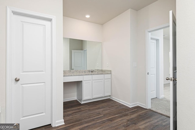 bathroom with baseboards, wood finished floors, recessed lighting, and vanity