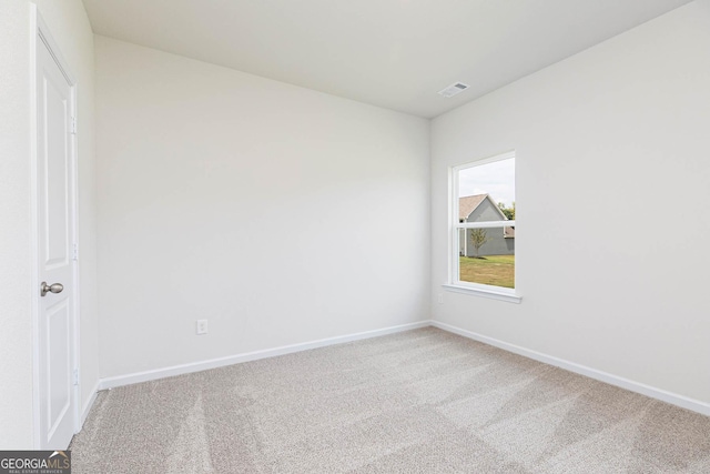 carpeted empty room featuring visible vents and baseboards